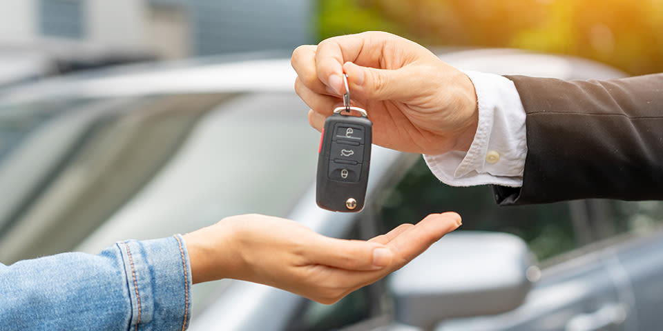 Mains qui donne les clés d'une voiture à une autre mains