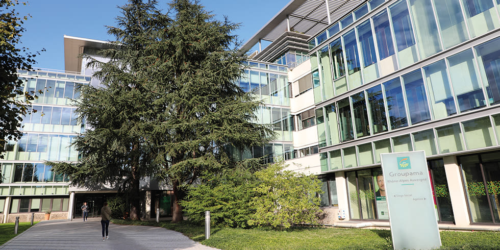 Conseiller d'assurances Groupama discutant à la porte d'une agence Groupama avec Cerise