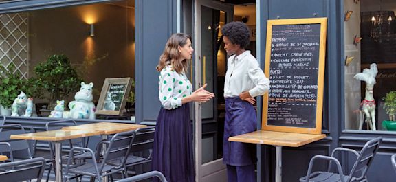 Cerise devant un restaurant qui parle avec la restauratrice