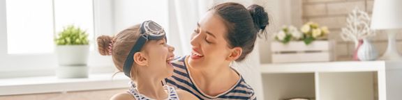 Une jeune femme et une petite fille s'amusent en faisant leurs valises.
