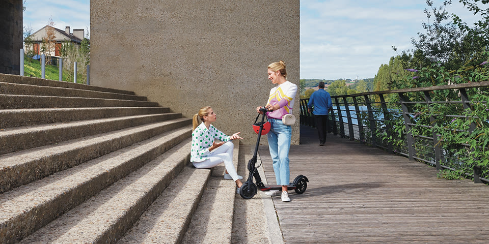 Cerise discute avec une cliente en trottinette électrique